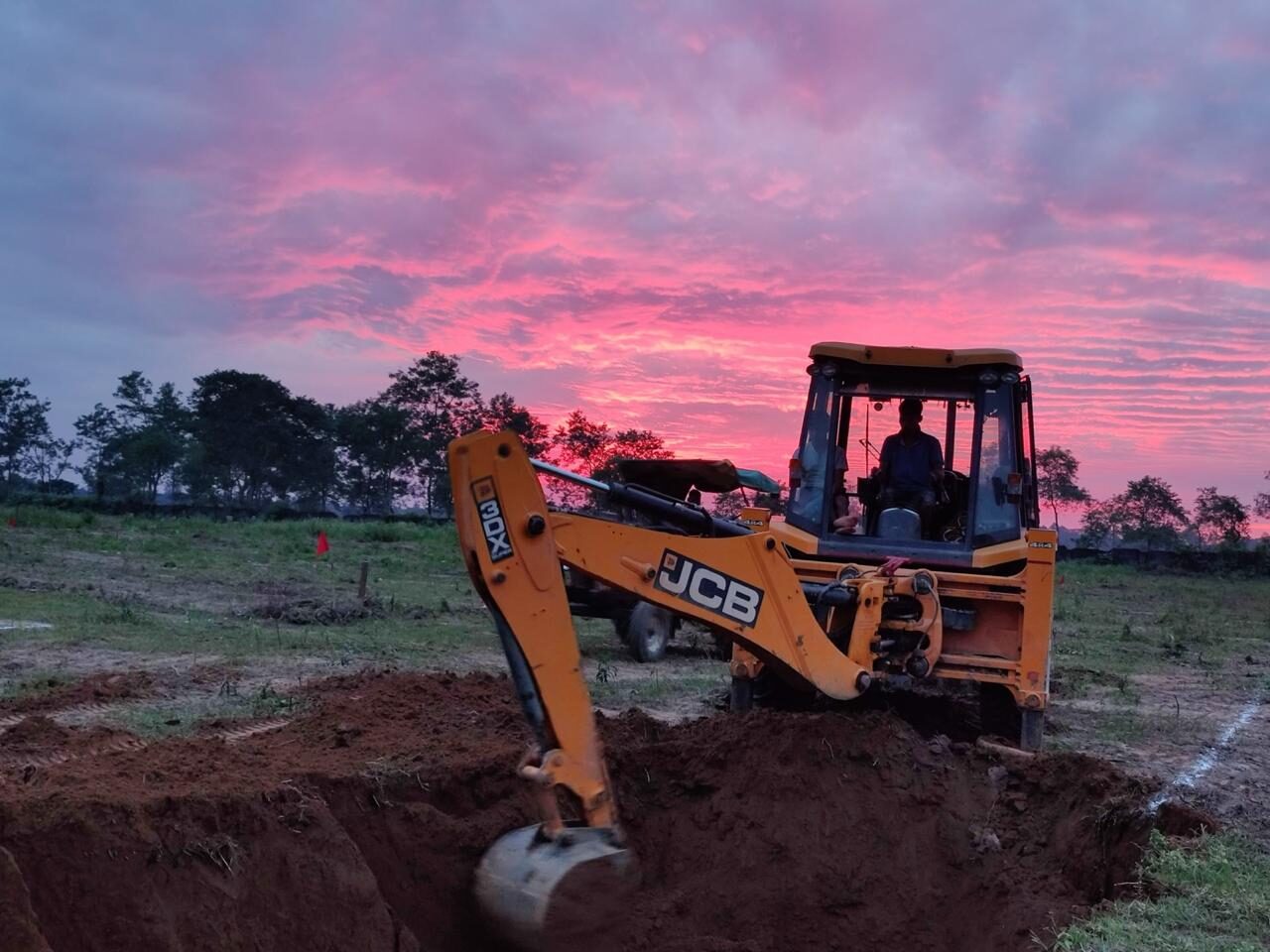 JCB backhoe working at sunset